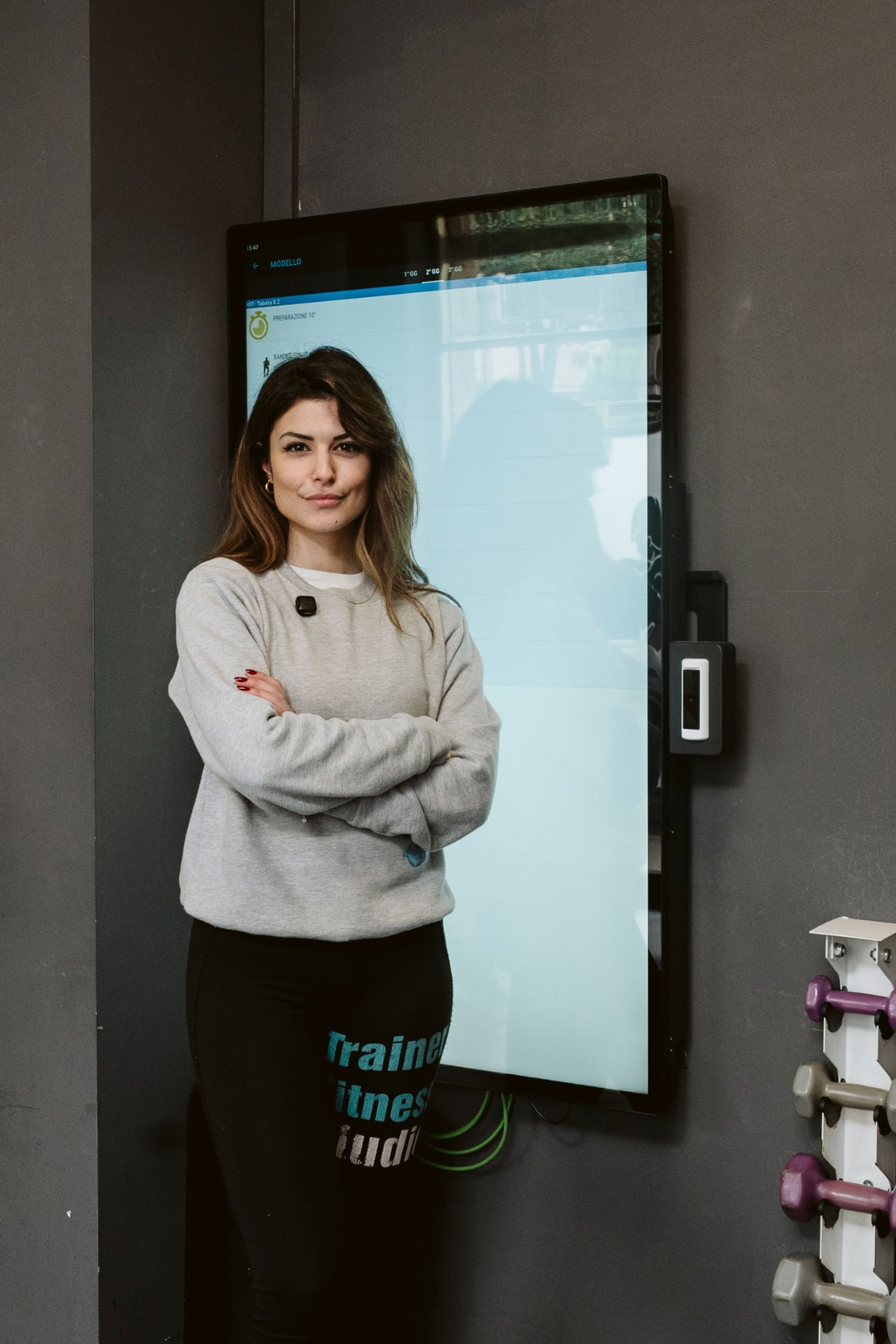 Trainer davanti allo schermo con la scheda di allenamento